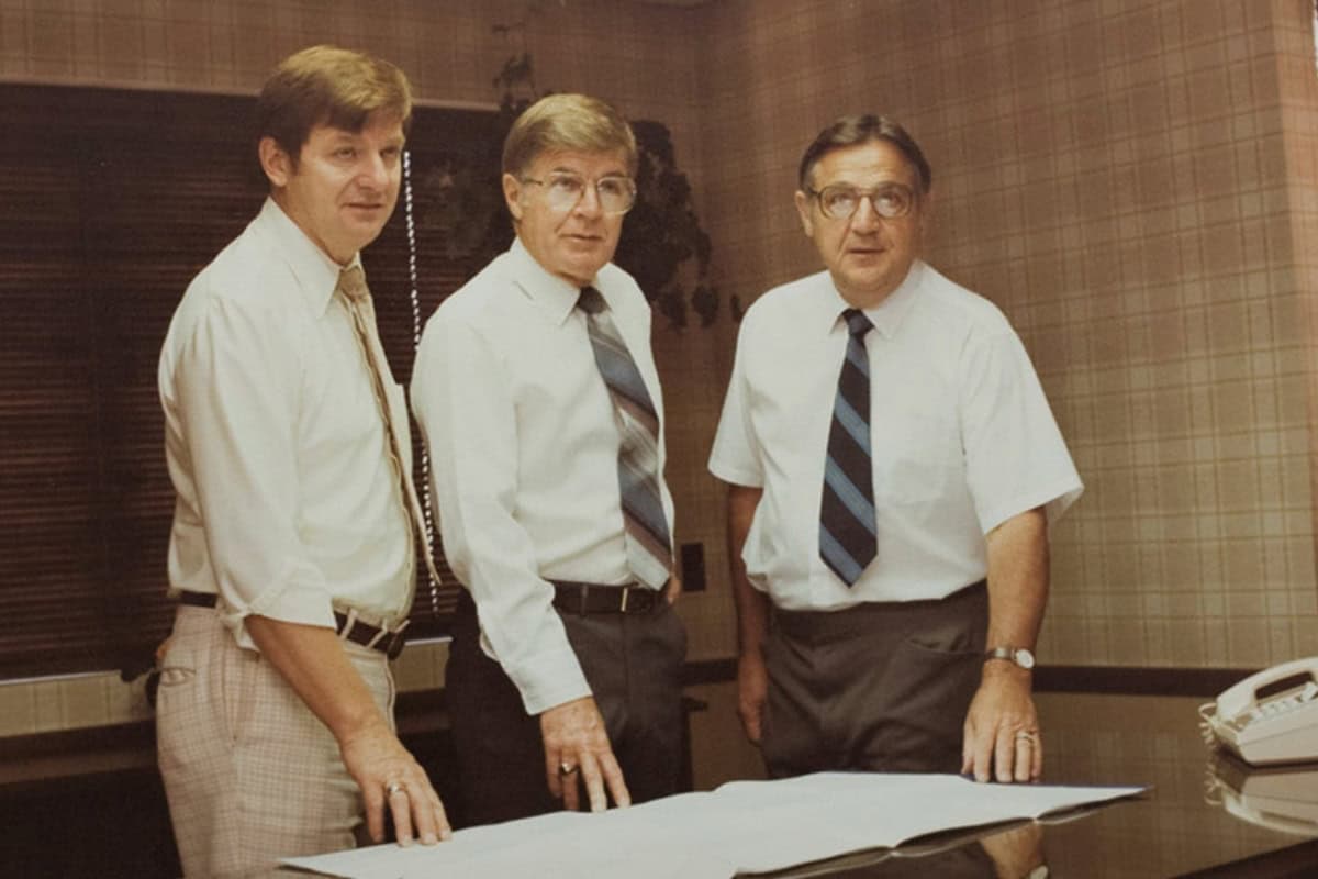 Three colleagues reviewing plans in 1961